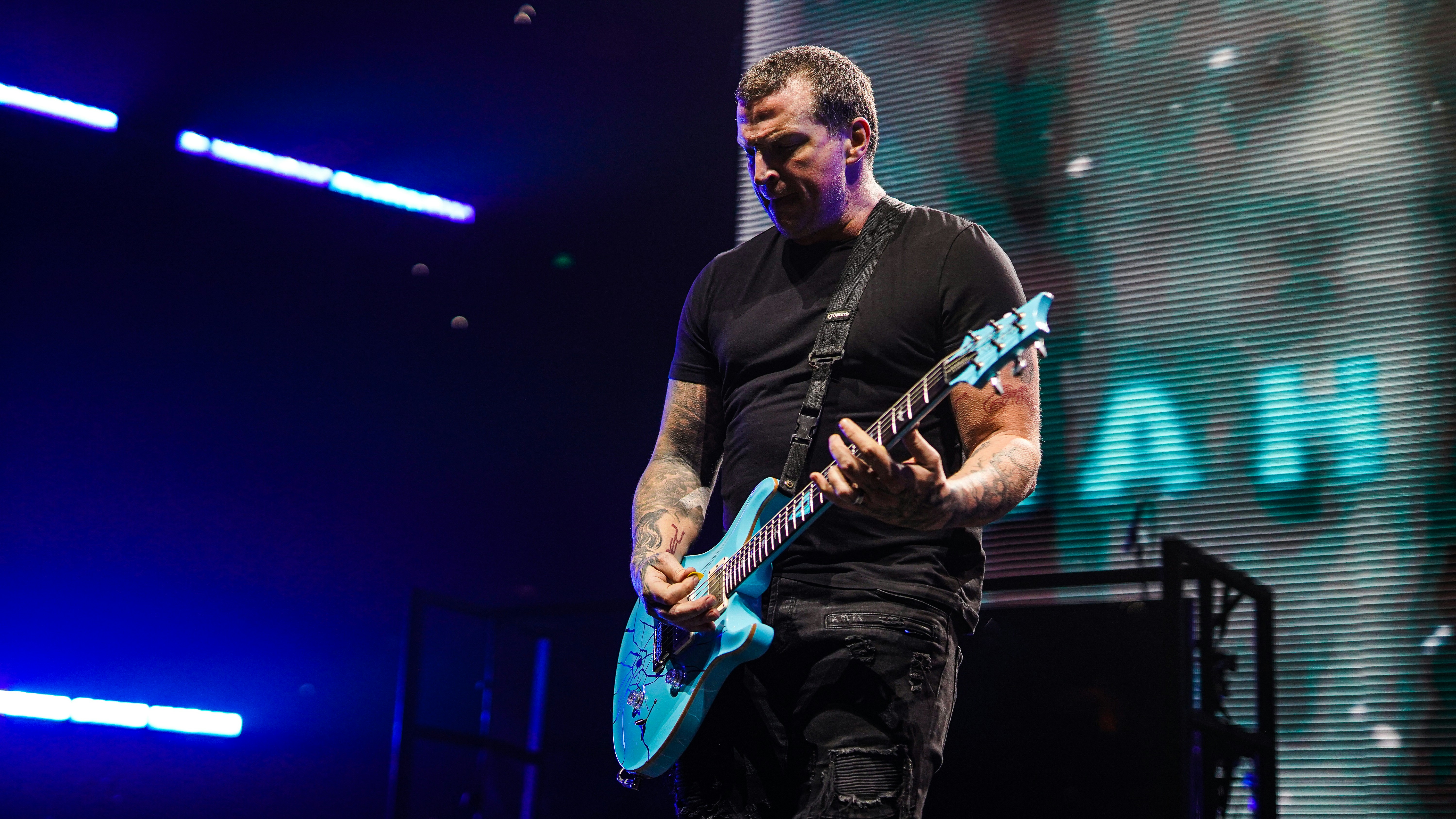 Guitarist playing a blue electric guitar