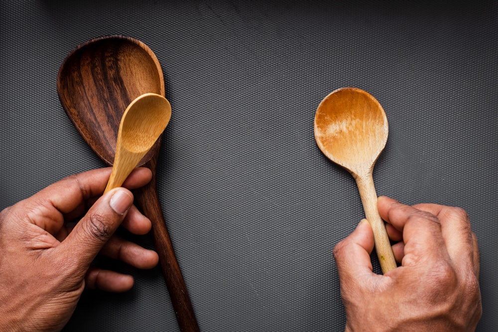 person holding brown wooden spoon