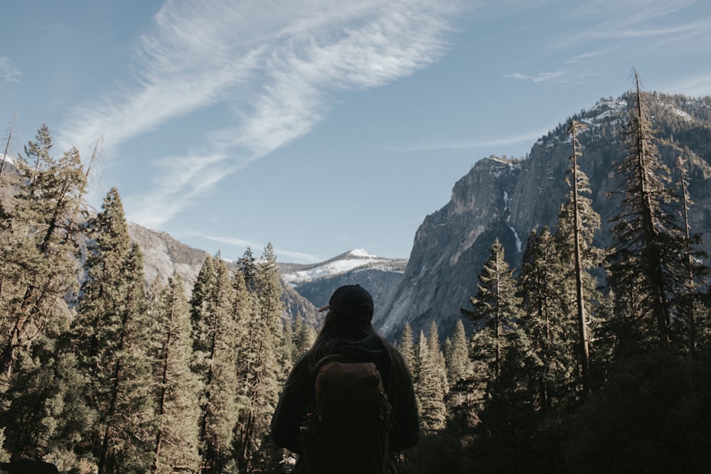 person in black jacket standing on mountain during daytime