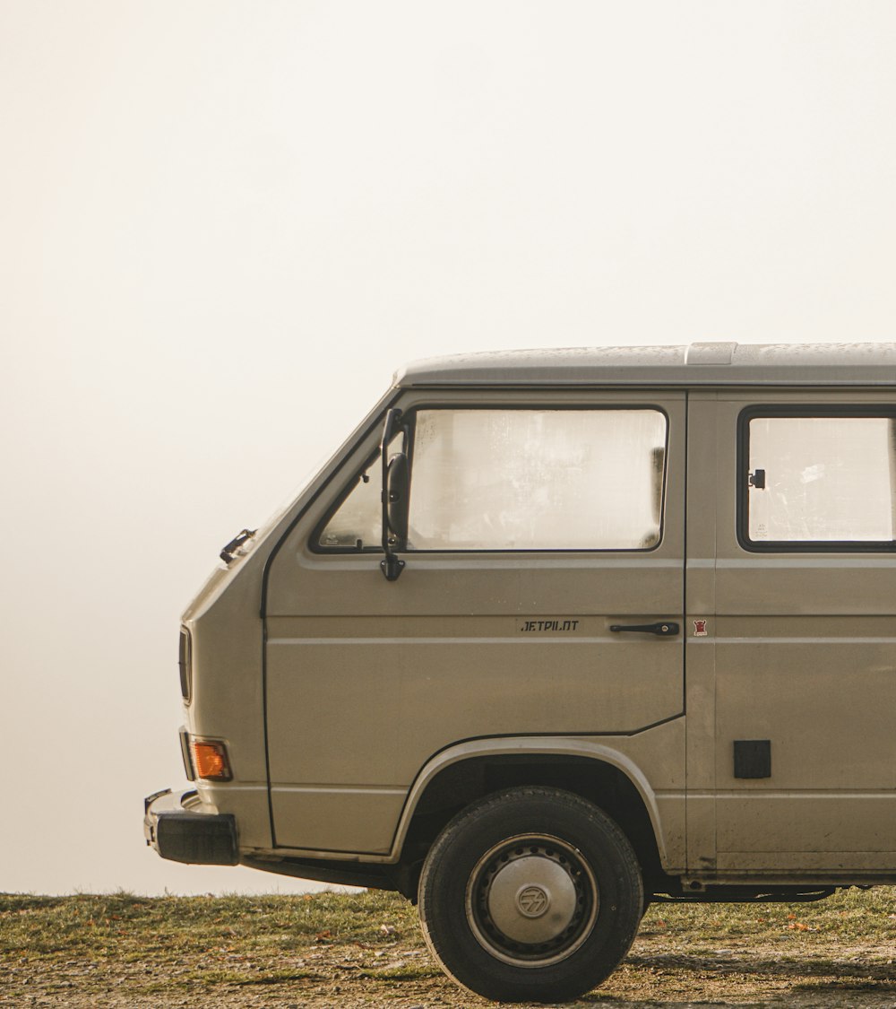 white van on green grass field under white sky during daytime