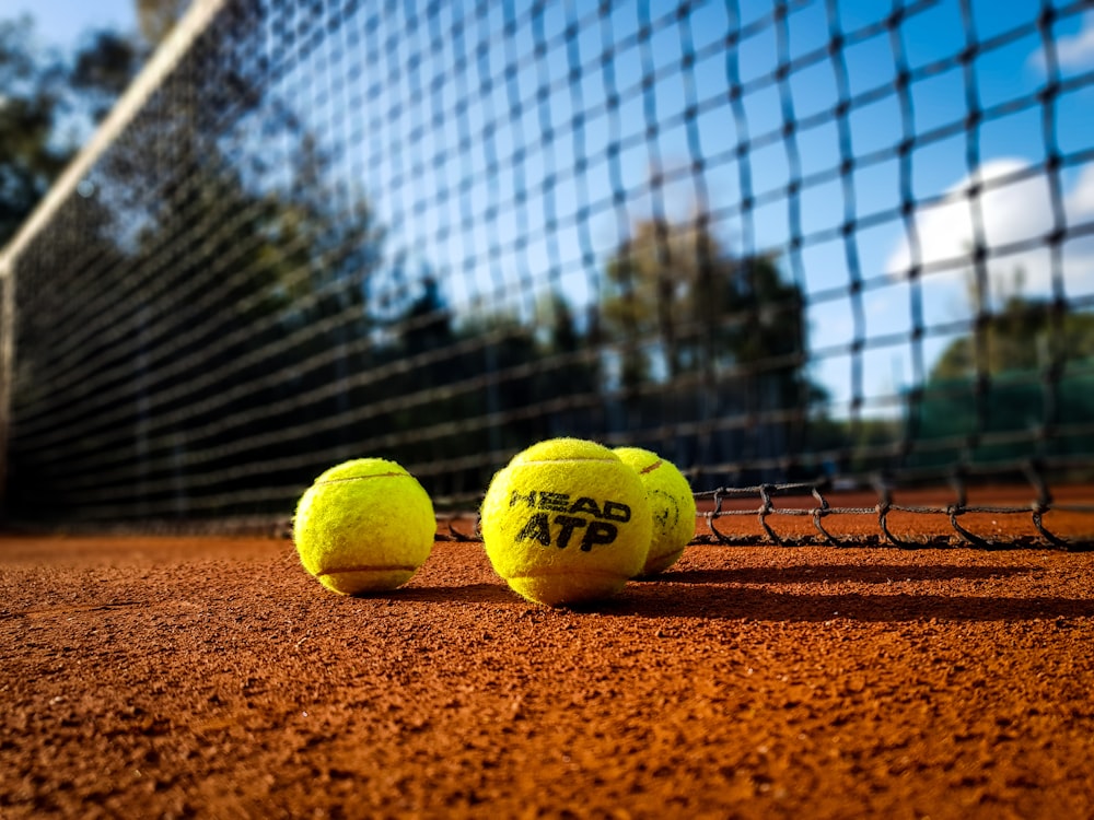 balle de tennis jaune sur sable brun