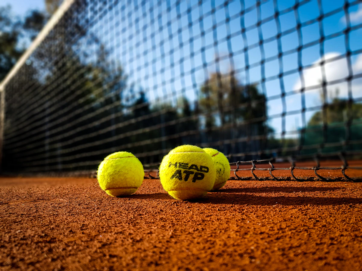 Toprak kort üzerinde sarı bir tenis topu, yakın plan