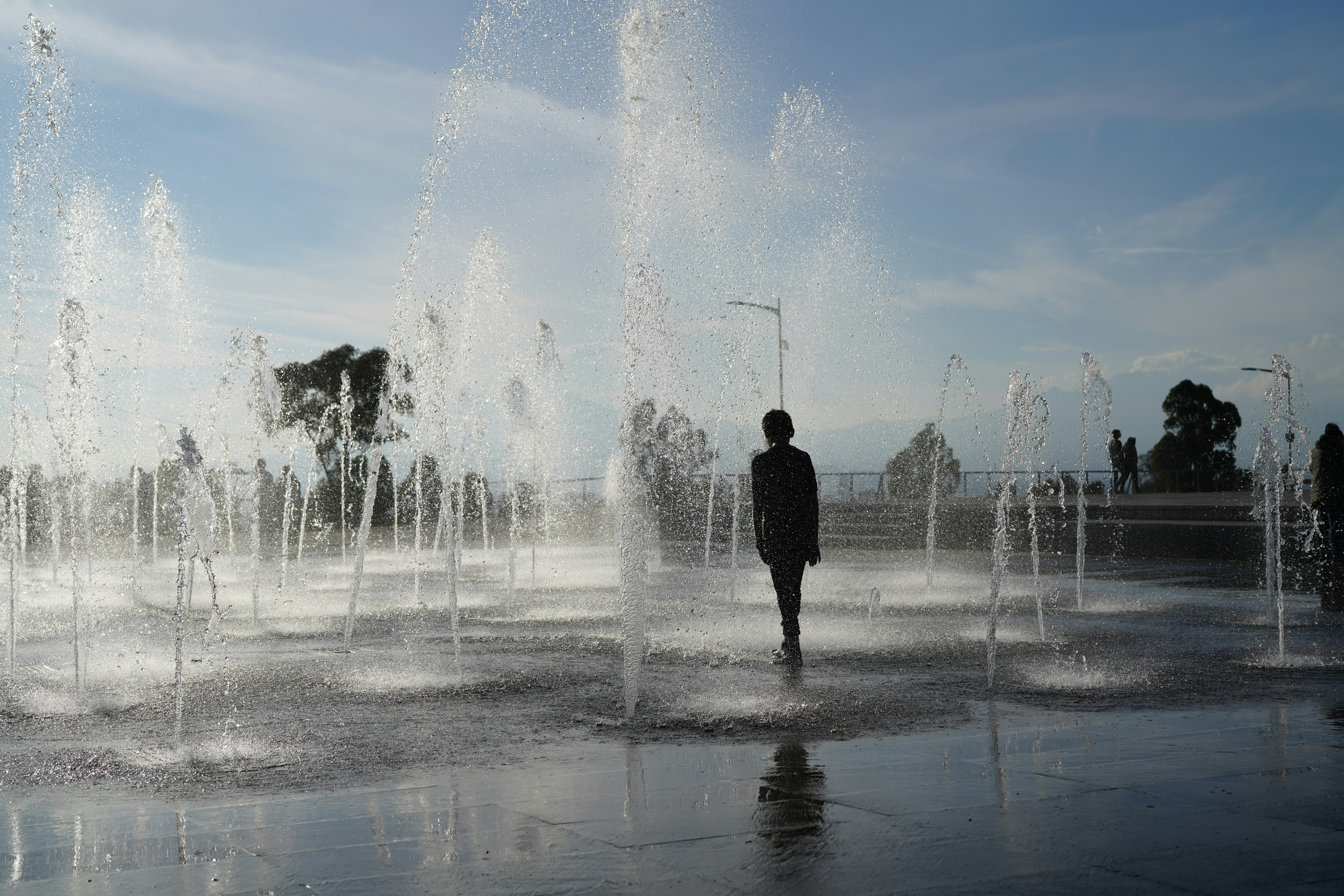 man standing in front of water fountain during daytime