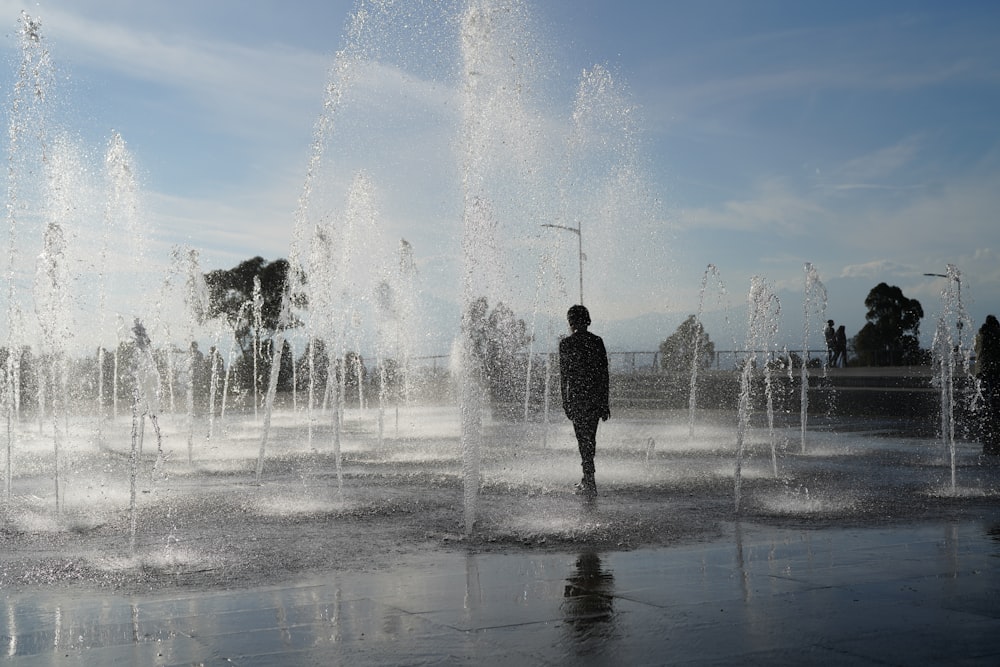 man standing in front of water fountain during daytime