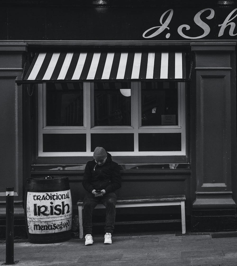 grayscale photo of man and woman sitting on bench