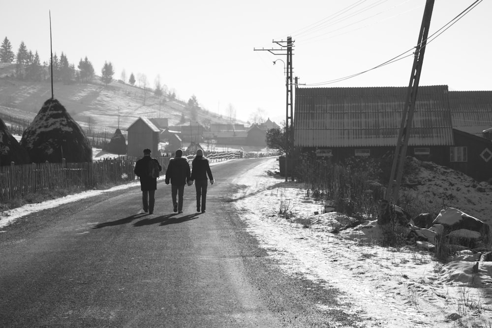 grayscale photo of 2 person walking on road