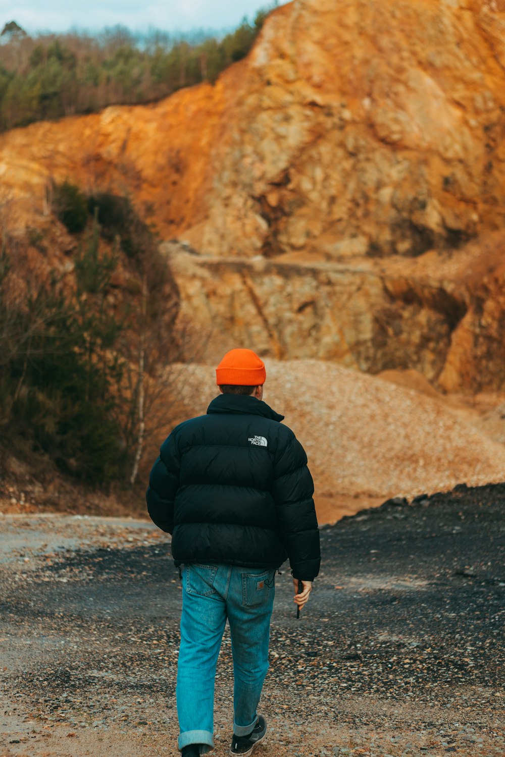 man in black jacket walking on road during daytime