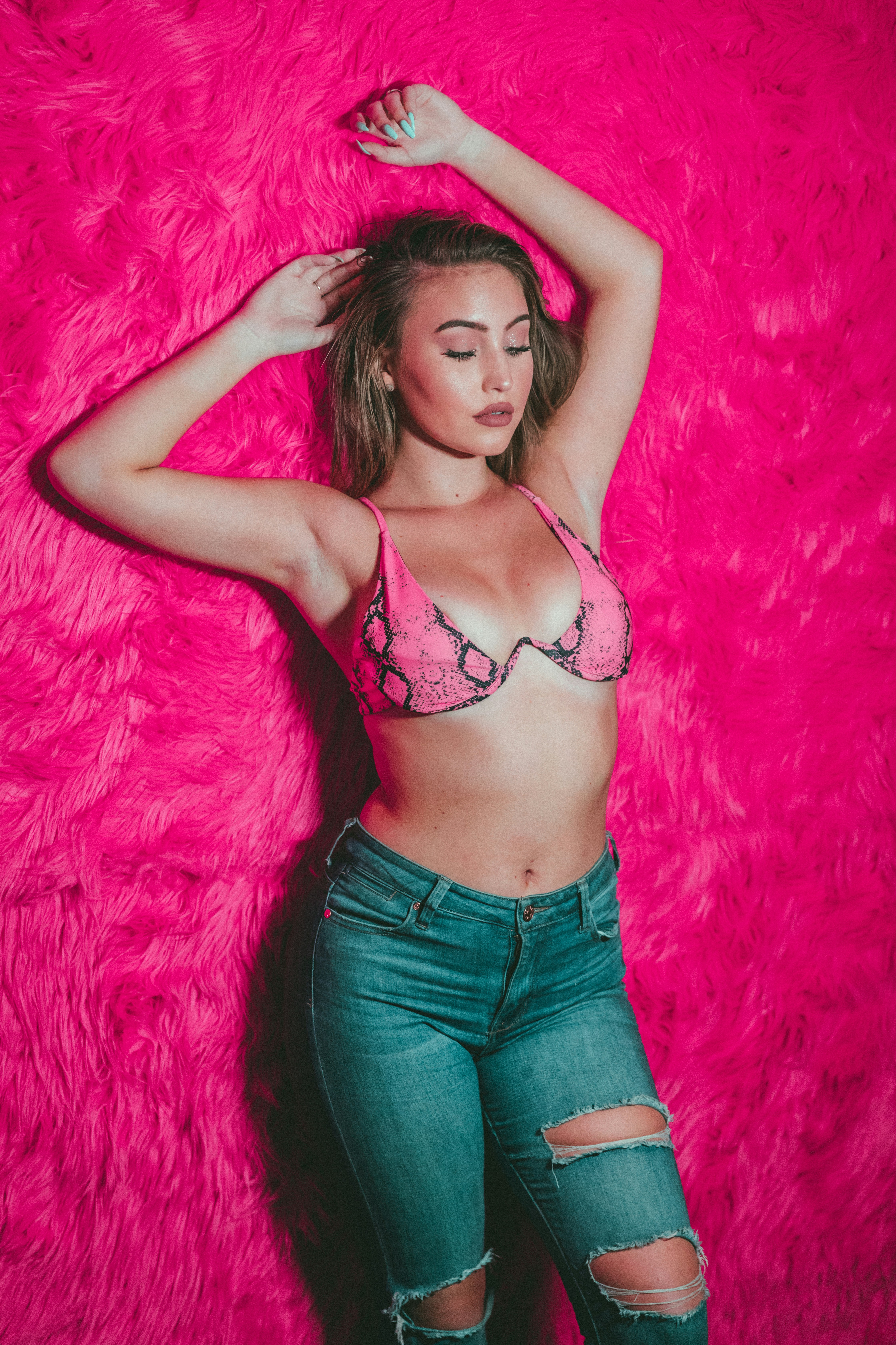 woman in blue denim jeans and black brassiere