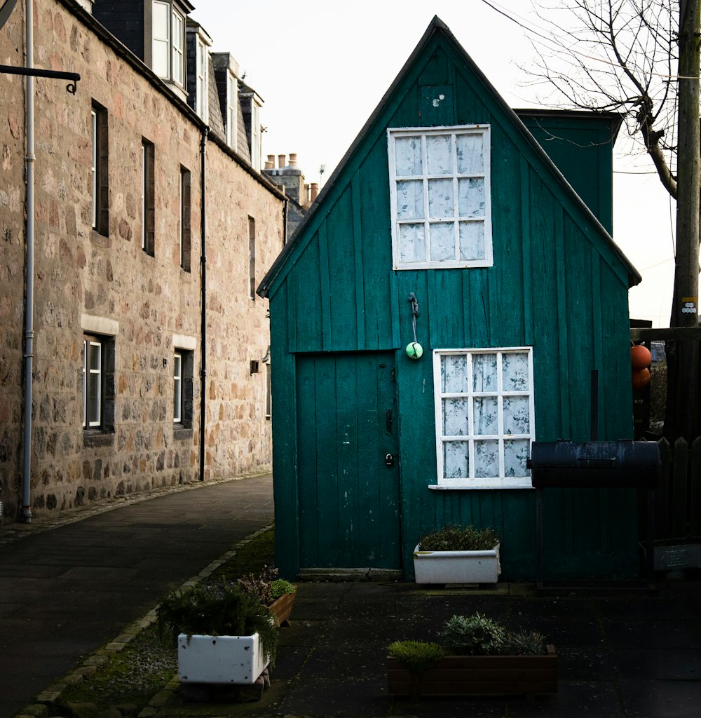 Maison en bois bleu près des arbres nus pendant la journée