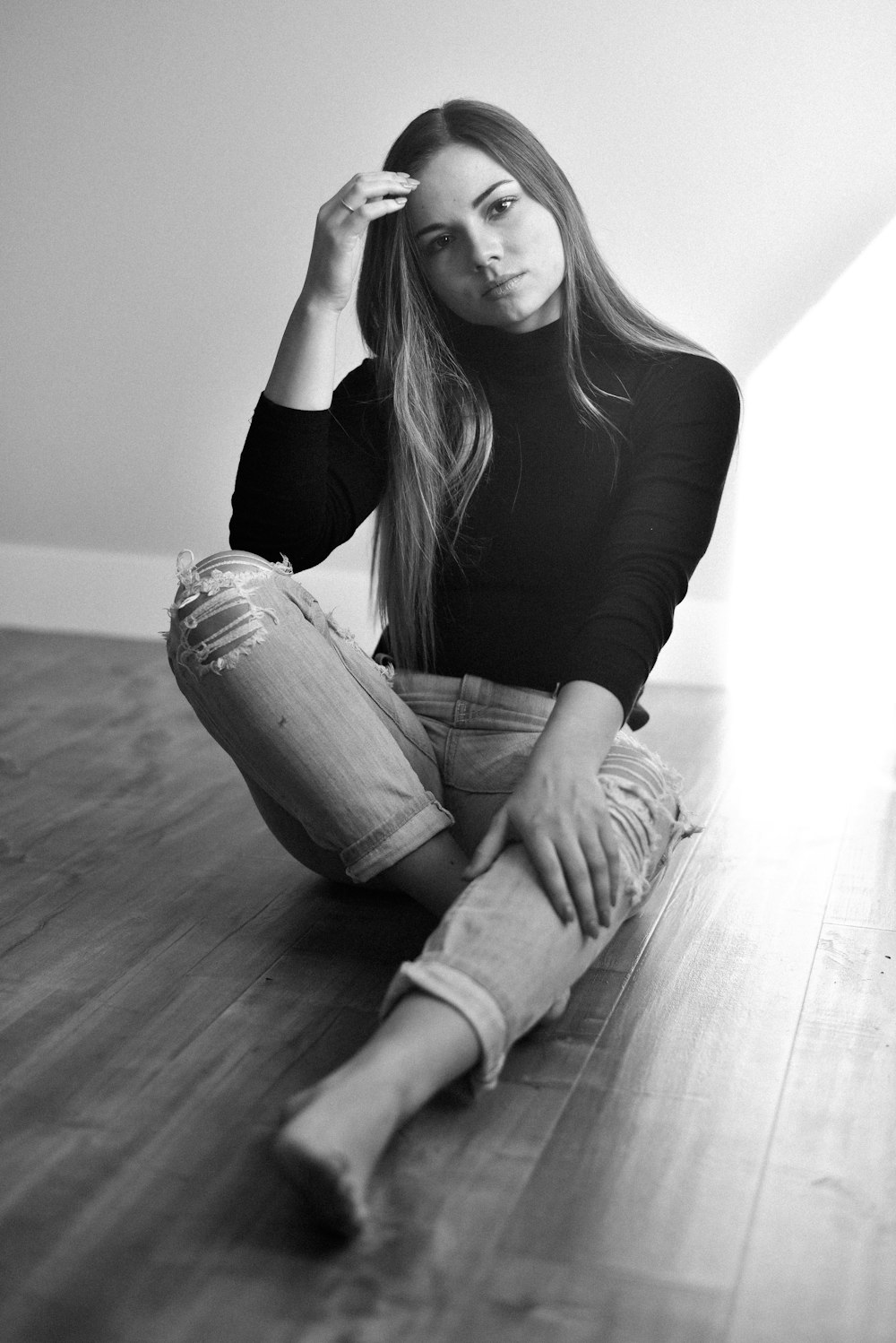 woman in black long sleeve shirt and blue denim jeans sitting on floor
