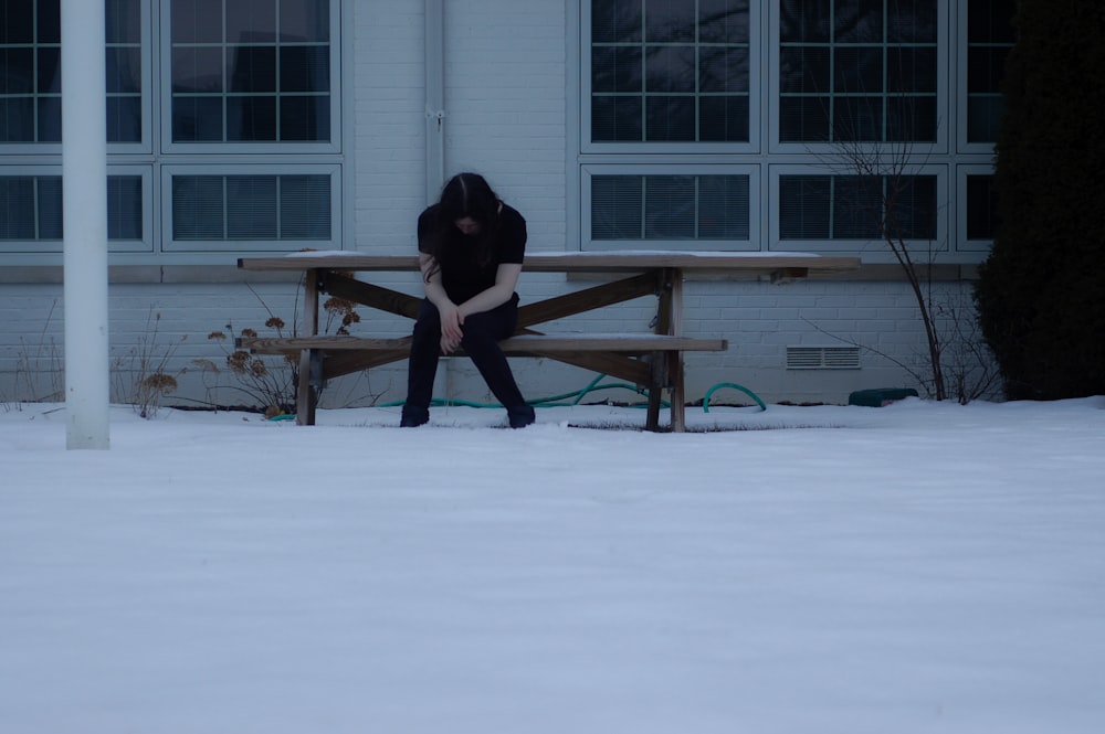 woman in black jacket and black pants standing on snow covered ground during daytime