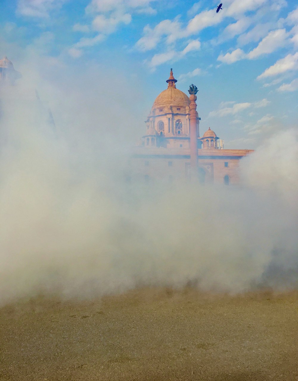 brown and white dome building under white clouds during daytime