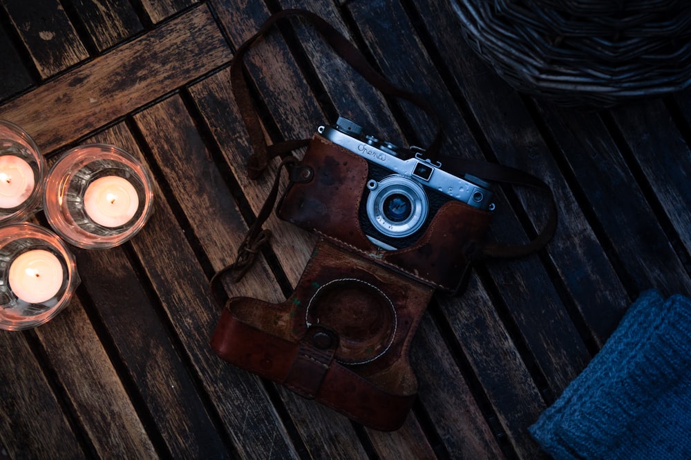 brown and silver dslr camera on brown wooden table