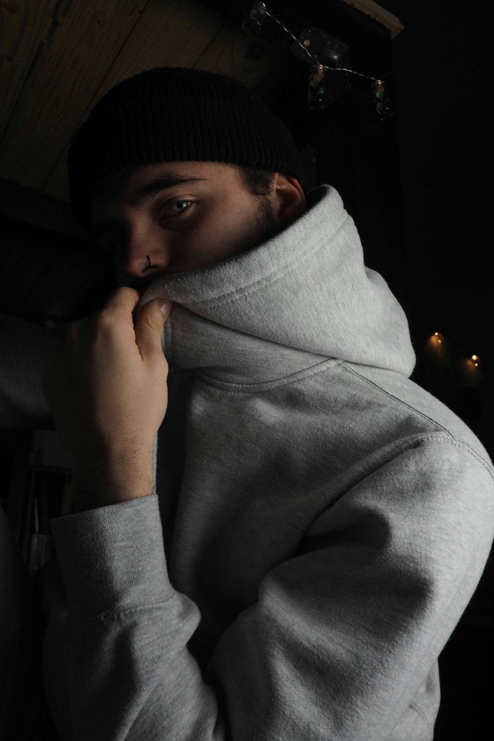 woman in gray sweater covering her face with gray scarf