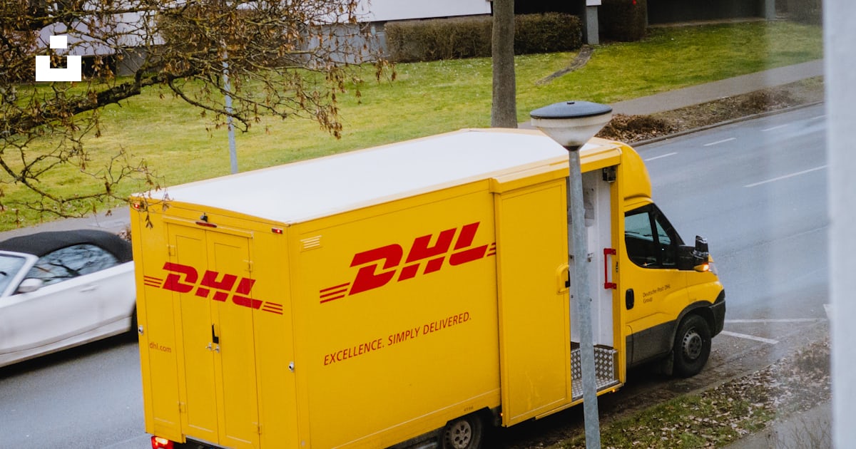 White And Orange Box Truck Parked Near Bare Trees During Daytime Photo picasso-wyland-worldwide