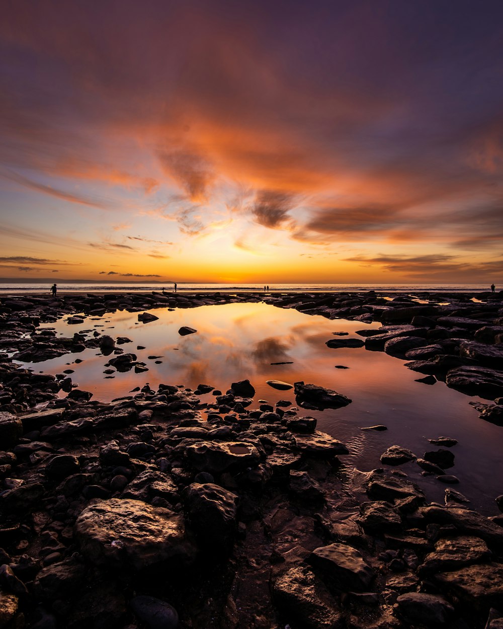 rocky shore under orange sunset