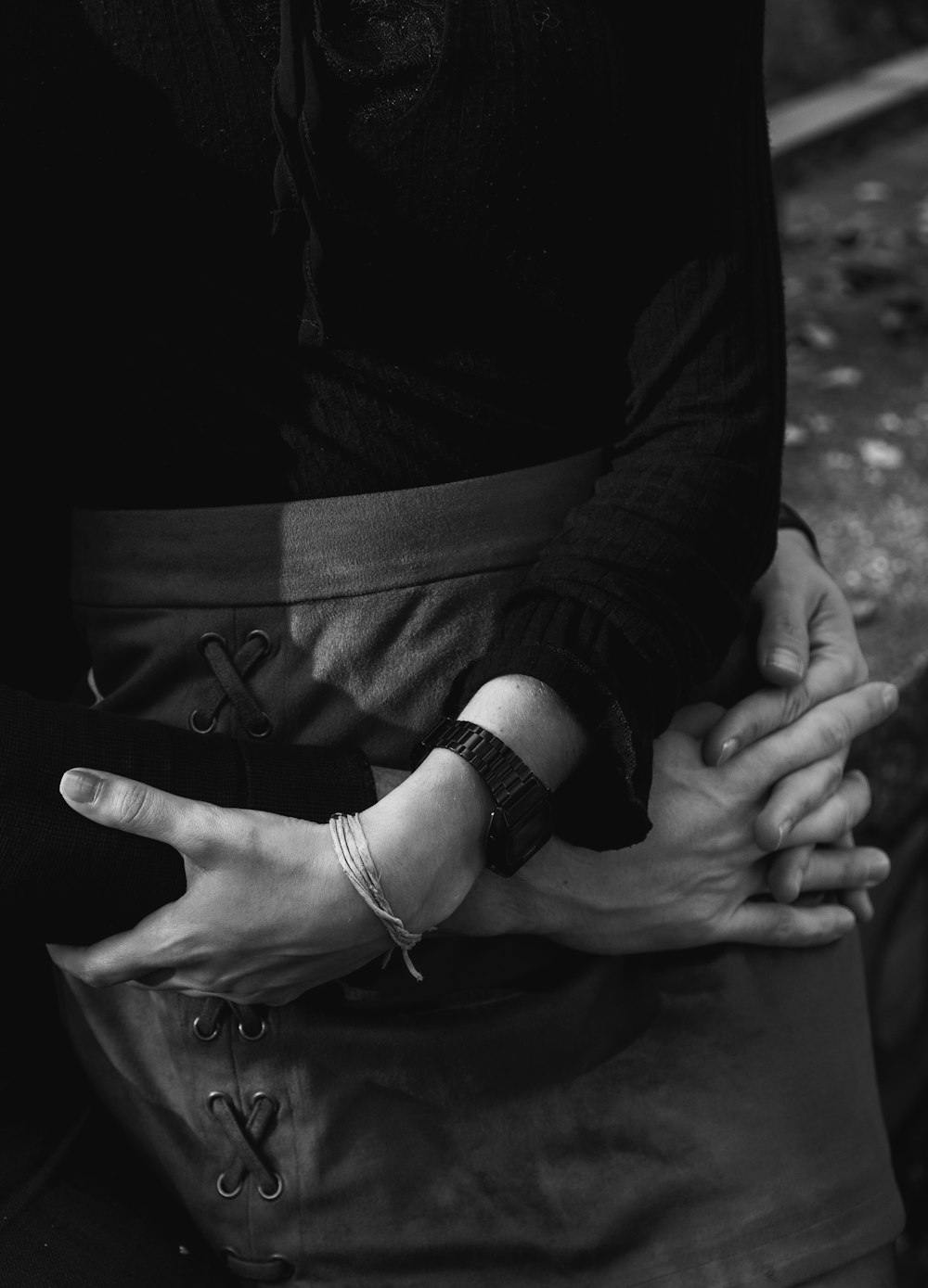 grayscale photo of person wearing black leather strap watch