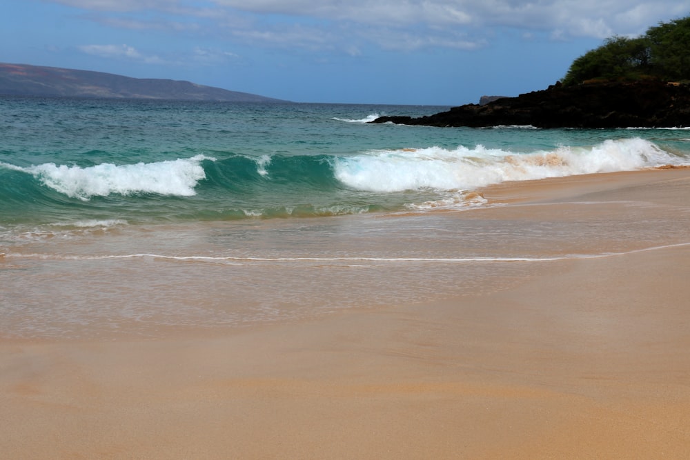 sea waves crashing on shore during daytime