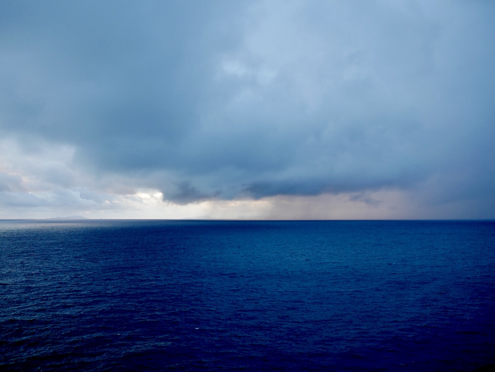 mar azul bajo nubes blancas durante el día