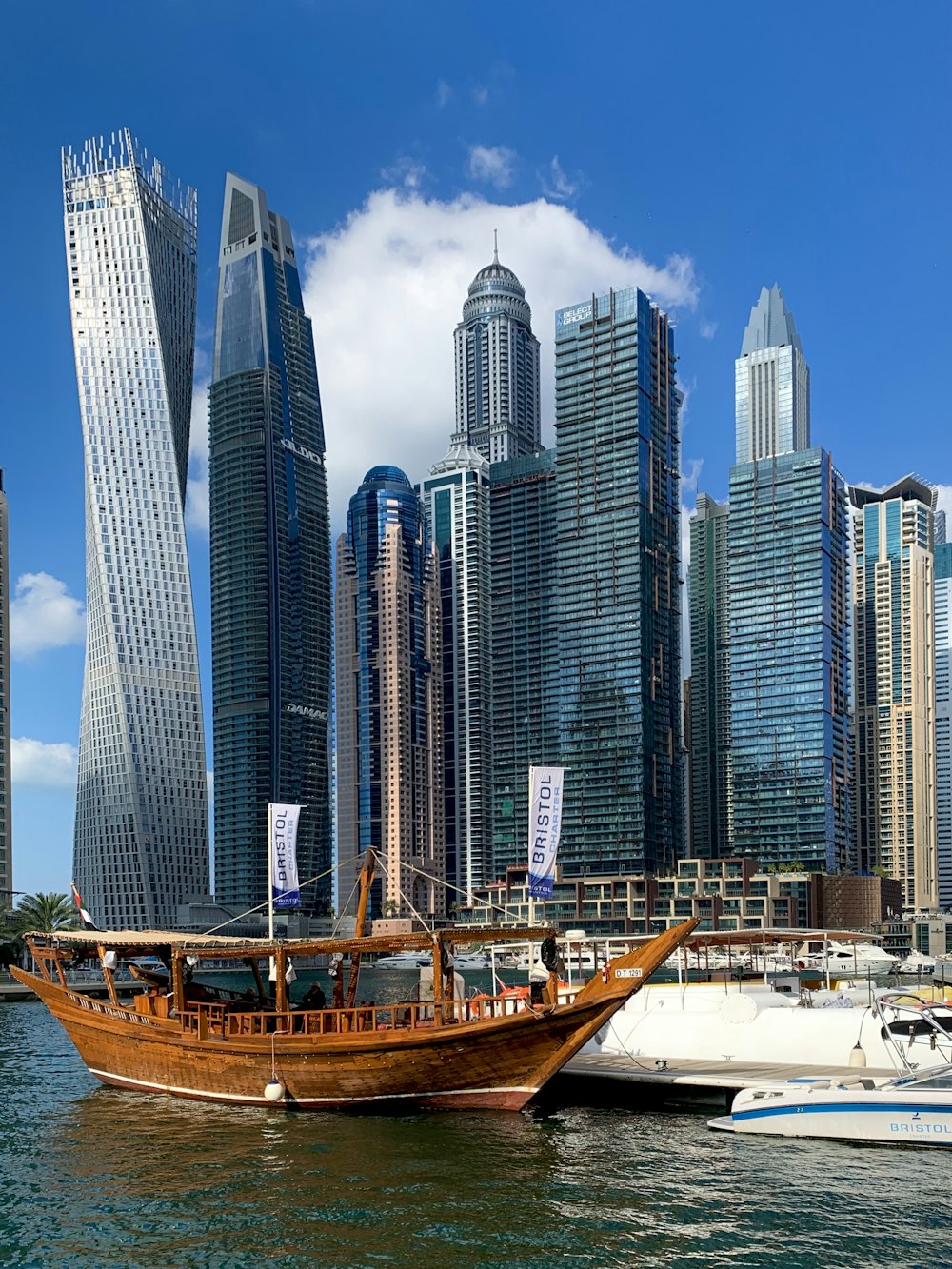 white and brown boat on dock near high rise buildings during daytime