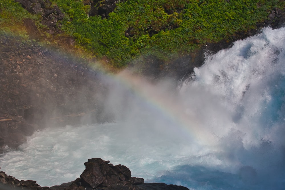 water falls on rocky shore during daytime