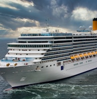 white cruise ship on sea under white clouds and blue sky during daytime