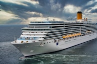 white cruise ship on sea under white clouds and blue sky during daytime