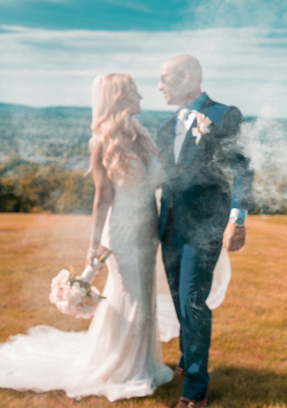 man in black suit holding woman in white wedding dress