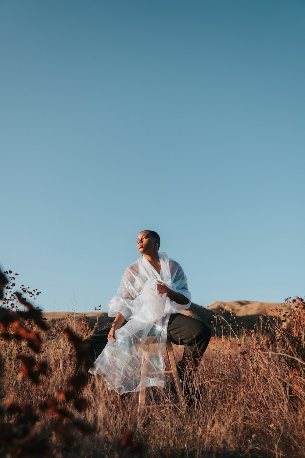 man in white dress shirt sitting on brown rock during daytime