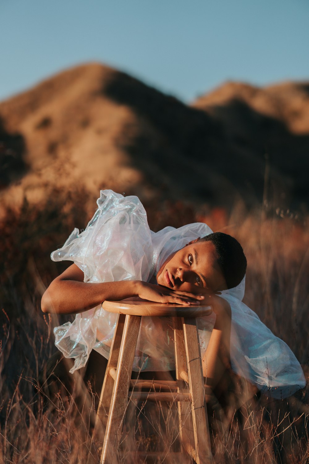 woman in white dress sitting on brown wooden chair