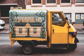 A sleek black and yellow Mercedes Vito minibus parked on a city street in The Hague at sunset.