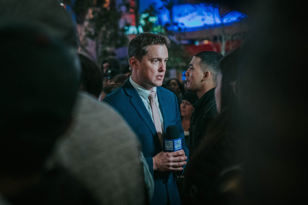 man in black suit standing in front of man in black suit