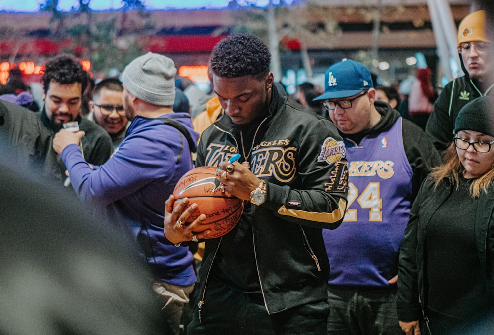 man in blue and yellow jacket holding brown football