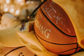 Close-up of a vintage basketball and handwritten notes from past women's games, displayed in a cozy archive setting.