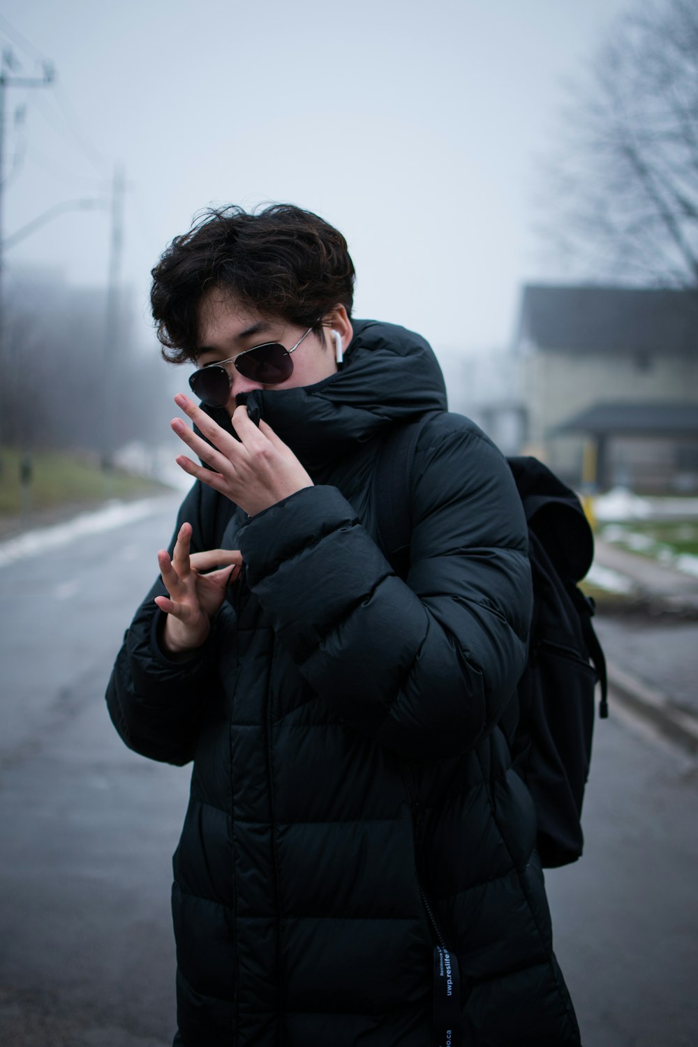 man in black jacket holding black smartphone