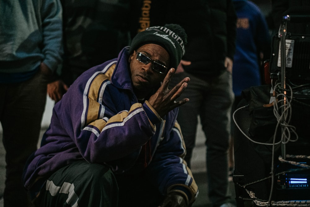 man in purple and yellow hoodie smoking cigarette