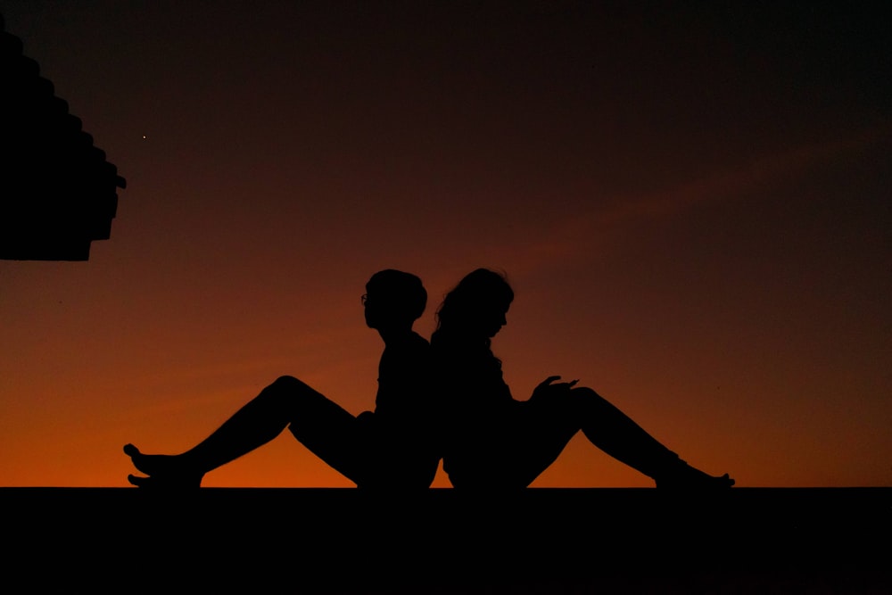 Silhouette von Mann und Frau, die sich während des Sonnenuntergangs küssen