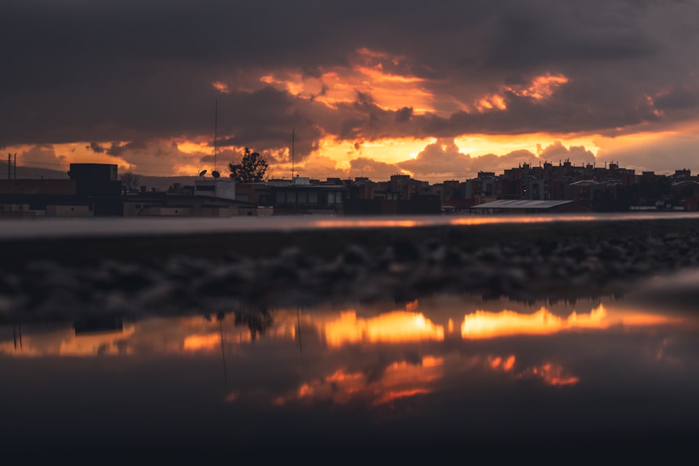 body of water near city during sunset