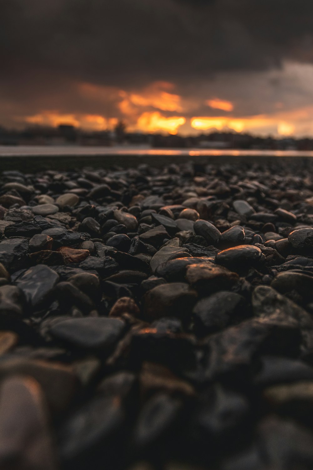black stones on the beach during sunset