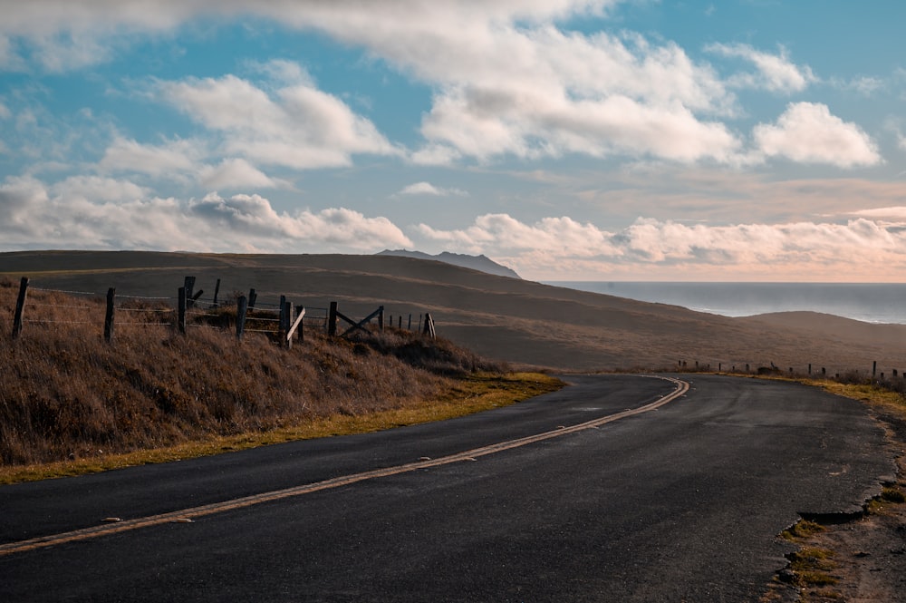 gray asphalt road under cloudy sky during daytime