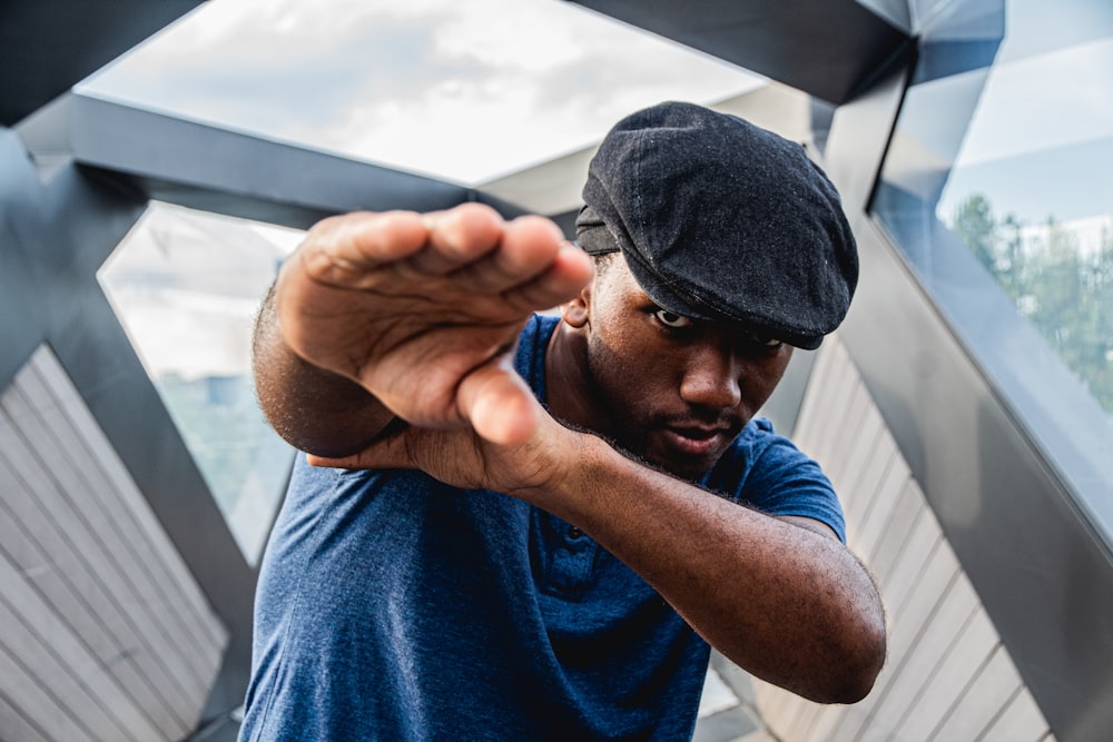 man in blue crew neck t-shirt wearing black cap