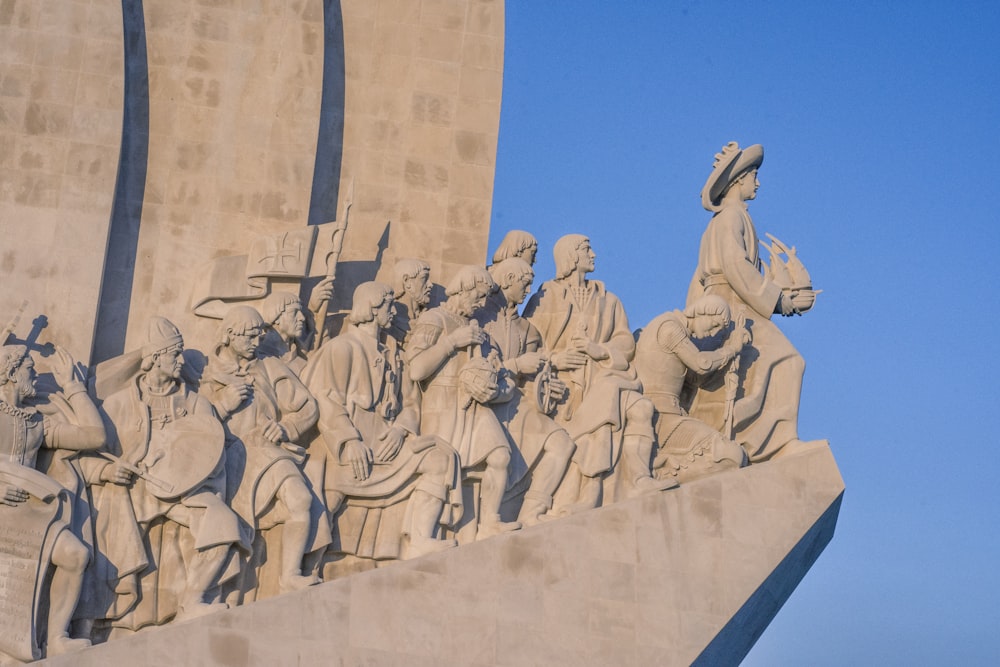 low angle photography of concrete statues under blue sky during daytime