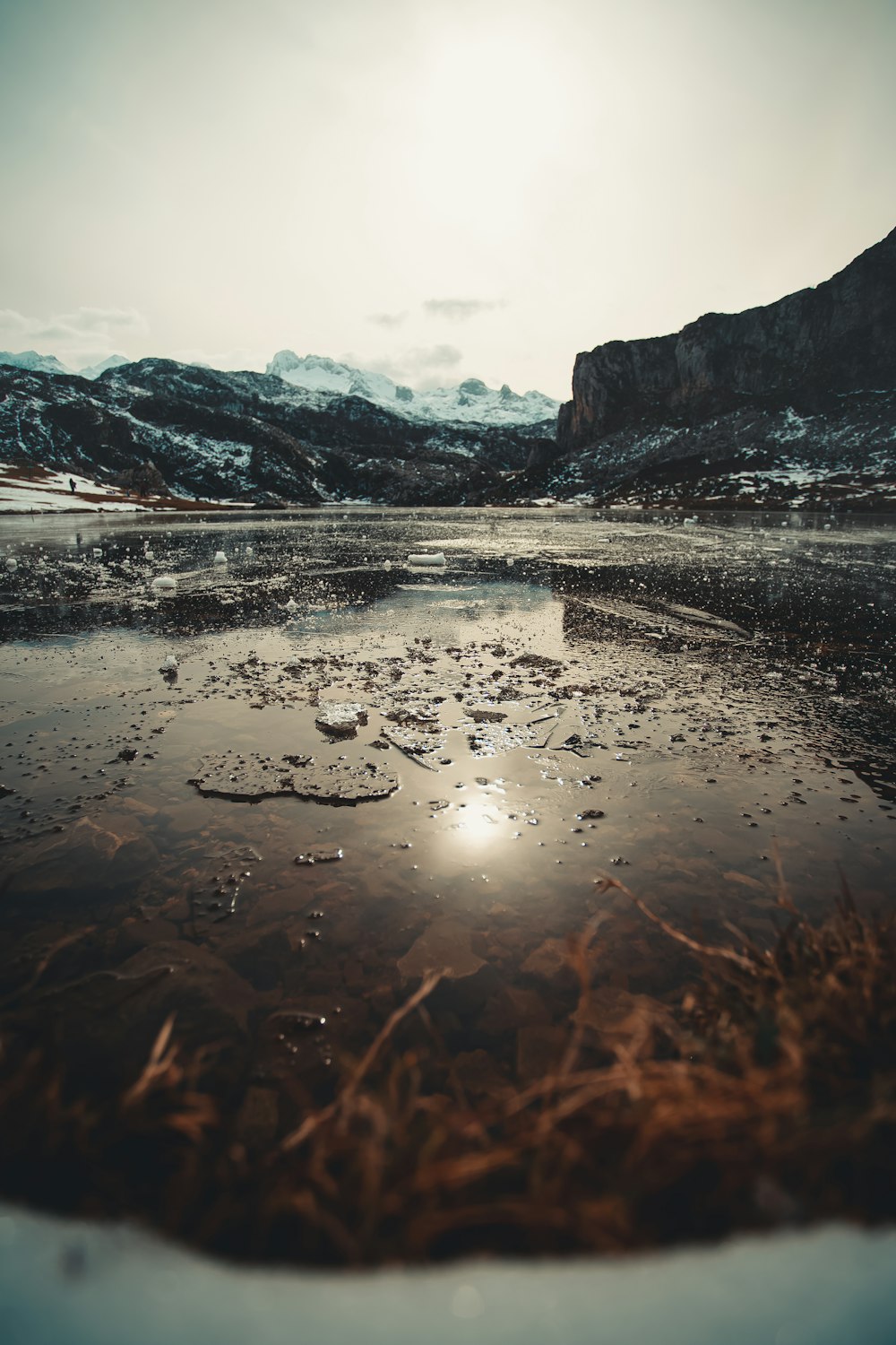 body of water near mountain during daytime