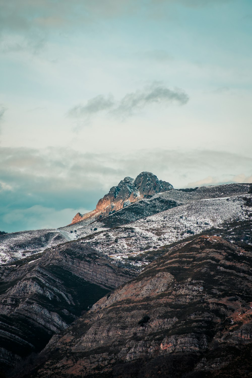 brown and gray rocky mountain under white cloudy sky during daytime