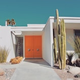 A beautiful modern house with a vibrant orange front door.