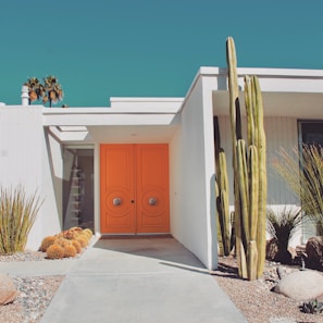 A beautiful modern house with a vibrant orange front door.
