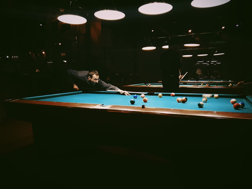 man in black suit playing billiard