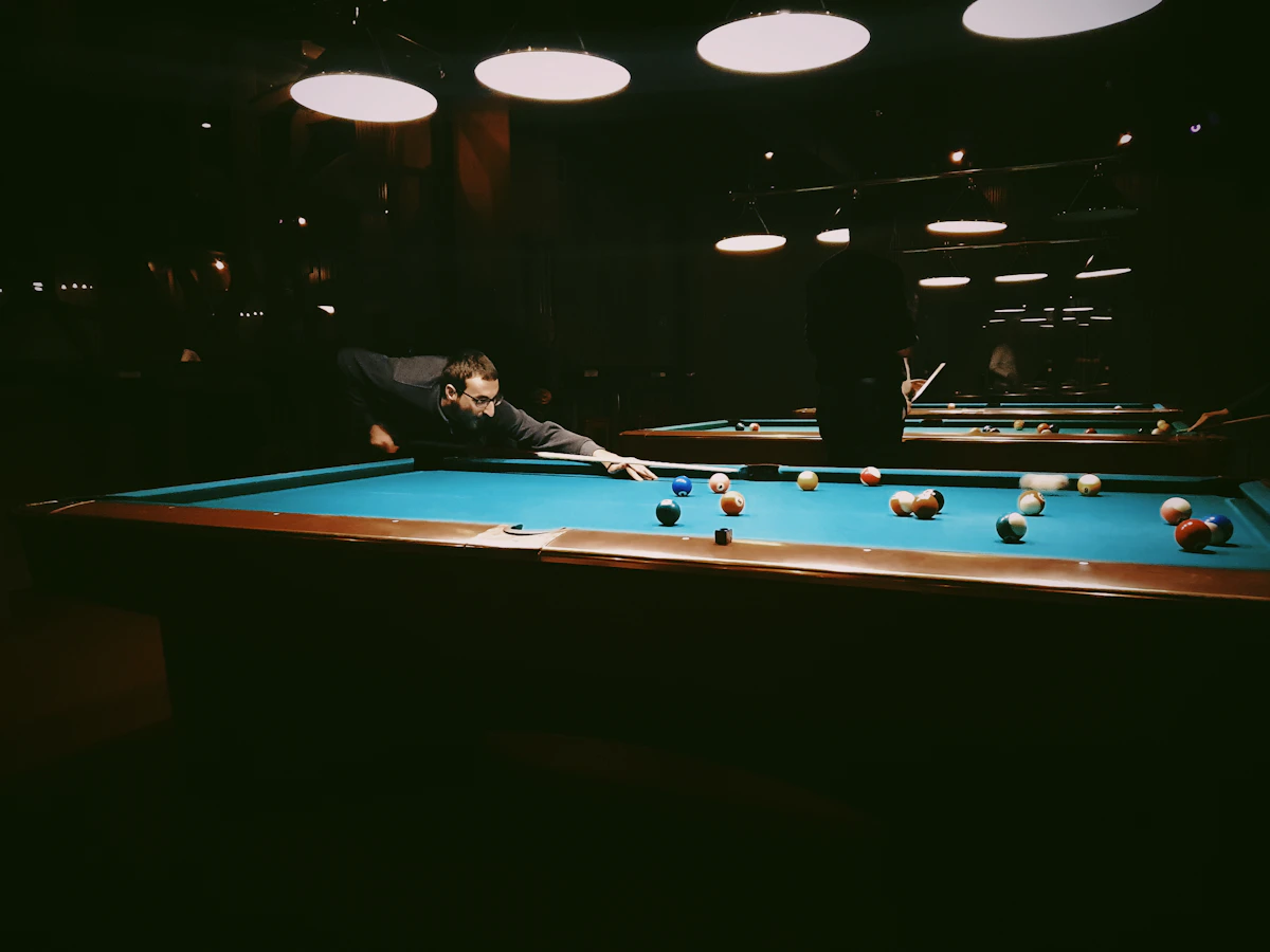 Joueur alignant un tir sur une table de billard
