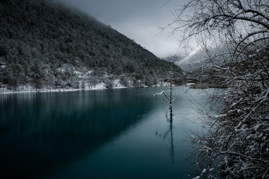 body of water near mountain during daytime in Lijiang China