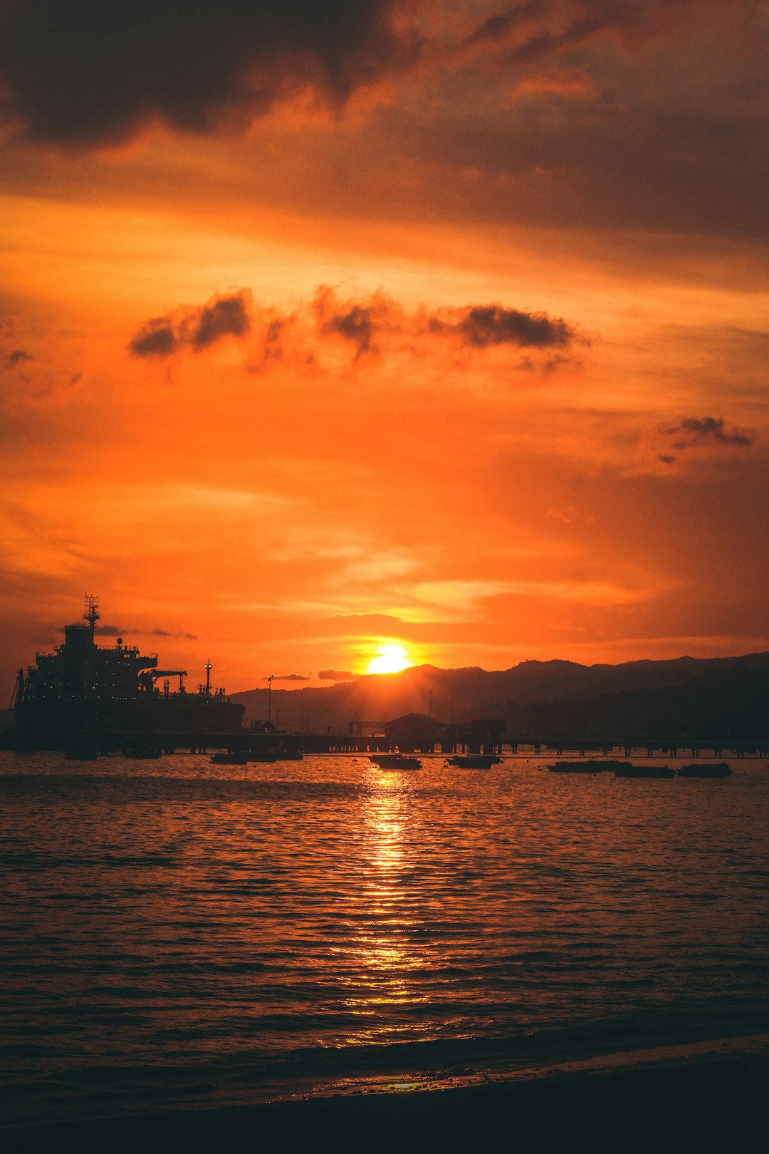 silhouette of building near body of water during sunset